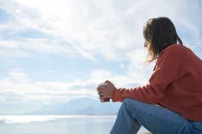 woman sitting in front of body of water